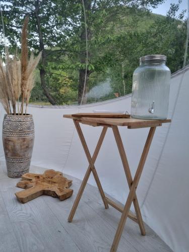 uma mesa de madeira com um vaso em cima em Camping les lodges du Tarn em Mostuéjouls