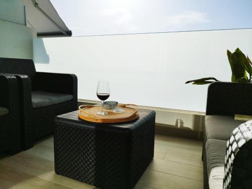 una copa de vino sentada en una mesa en una habitación en Amplio y cómodo apartamento., en Granadilla de Abona