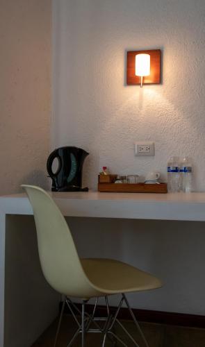 a white chair sitting at a desk with a light at Casa Pepe in Puebla