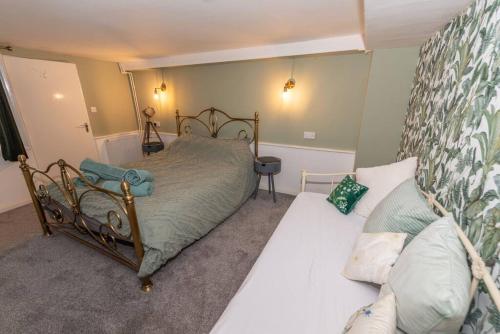 a bedroom with a bed and a couch at The Tempest, sea views, coastal & rural walks. in Ilfracombe