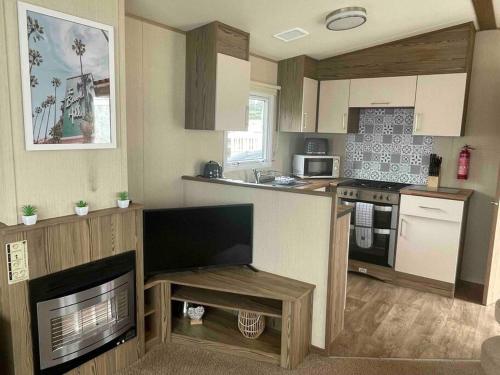 a kitchen with a counter and a stove top oven at Tarka Holiday Park - Summer Breeze - Coastal Breaks - North Devon - Braunton-Barnstaple in Ashford