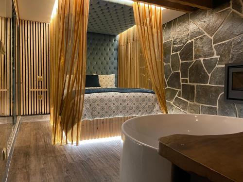 a bathroom with a bath tub and a bed at Muas Guest House in Vila Real