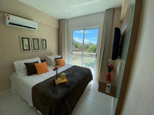 a hotel room with a bed and a window at Apartamento Palm Beach - 300m Beach Park in Aquiraz