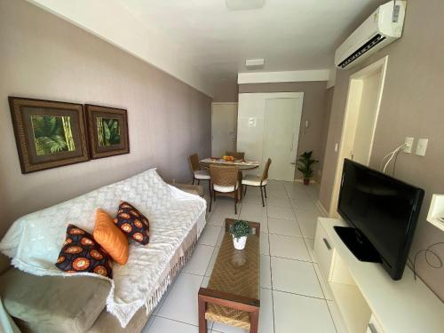 een woonkamer met een bank en een tafel bij Apartamento Palm Beach - 300m Beach Park in Aquiraz