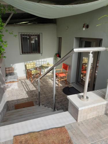 a house with a staircase and a table and chairs at Helen's cozy studio (close to the airport) in Koropi