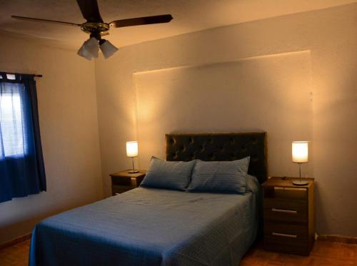 波特雷羅德加雷的住宿－Potrero de Garay，一间卧室配有一张带2个床头柜和2盏灯的床。