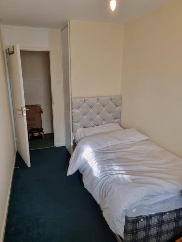 a bedroom with a bed in the corner of a room at 6 Greville Court in London