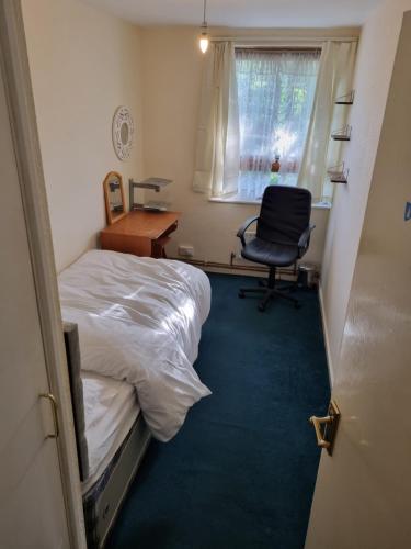 a room with two beds and a desk and a chair at 6 Greville Court in London