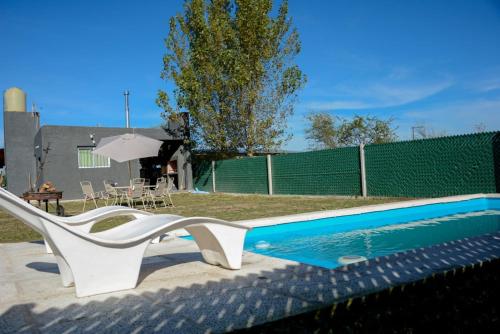 波特雷羅德加雷的住宿－Potrero de Garay，一个带滑梯的游泳池,旁边是一张桌子和一把遮阳伞