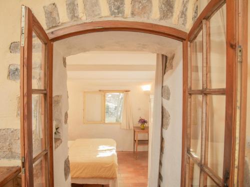 une porte ouverte vers une chambre avec un lit dans l'établissement La Bergerie, à Cotignac