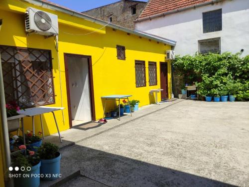 a yellow building with a table in front of it at Sobe sa sopstvenim KUPATILOM Private rooms bathroom In CENTER in Novi Sad