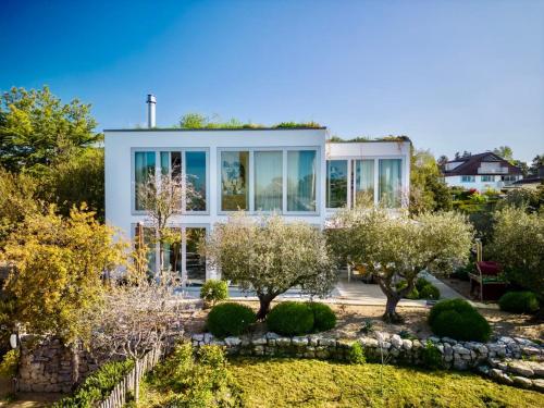 a house with a garden in front of it at Villa Serenity Sustainable Luxury Retreat by GuestLee in Preverenges