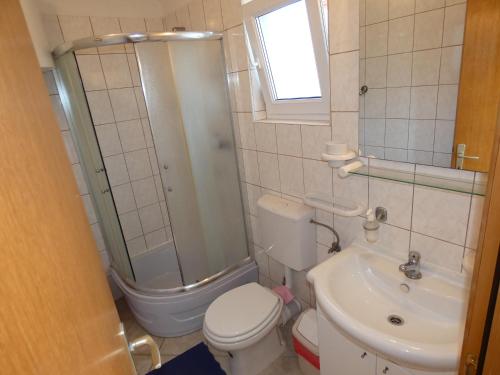 e bagno con doccia, servizi igienici e lavandino. di Apartments with a parking space Vinisce, Trogir - 11075 a Vinišće