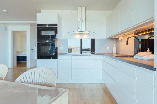 une cuisine avec des placards blancs et un comptoir dans l'établissement Stunning Sea View / 1 bedroom apartment / Tórshavn, à Tórshavn