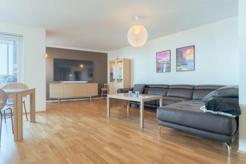 a living room with a couch and a table at Stunning Sea View / 1 bedroom apartment / Tórshavn in Tórshavn