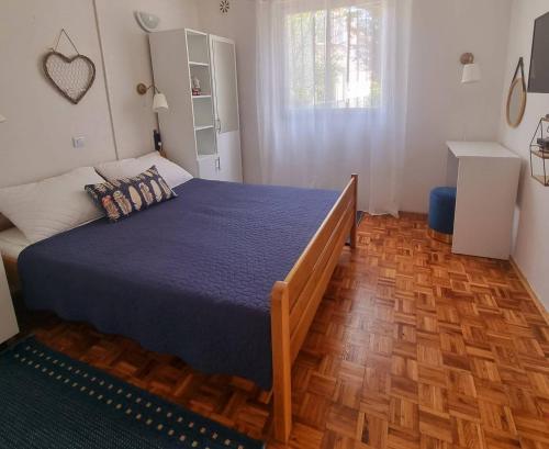 een slaapkamer met een groot bed en een blauwe deken bij Apartments with a parking space Sabunike, Zadar - 14574 in Nin
