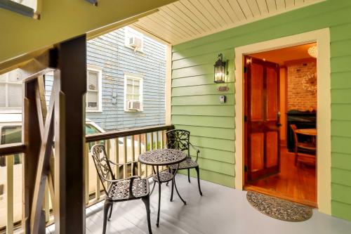 a porch with two chairs and a table on a balcony at Victorian Vacation Rental Apt in Downtown New Bern in New Bern