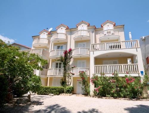 a large white building with balconies and flowers at Apartments by the sea Bol, Brac - 2904 in Bol