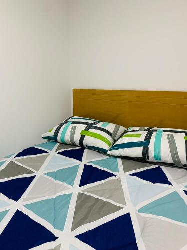 a bed with a blue and white quilt and pillows at Bogotá Kings 301 in Bogotá