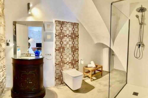 uma casa de banho com um WC e uma cabina de duche em vidro. em La Casa de Ubeda em Úbeda