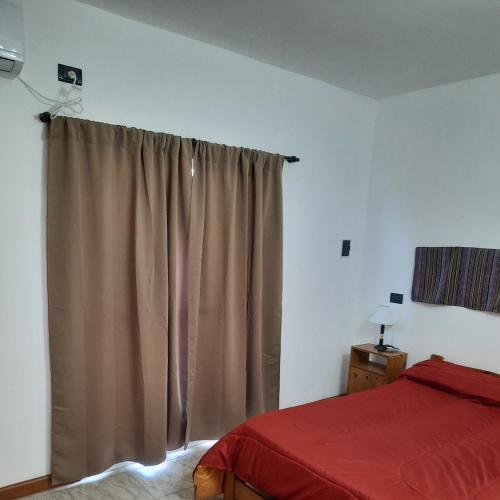 a bedroom with a bed and a curtain at RUKA Apart in Chilecito