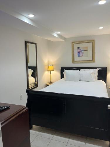 a bedroom with a large bed and a mirror at COMFY Basement Home 2 Bdrm1Den 3Queen Beds in Washington, D.C.