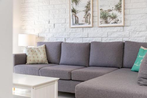 a living room with a couch and a white brick wall at Mirabeau in Forster