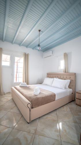 a bedroom with a large bed with a blue ceiling at Irene's Residence in Mikonos