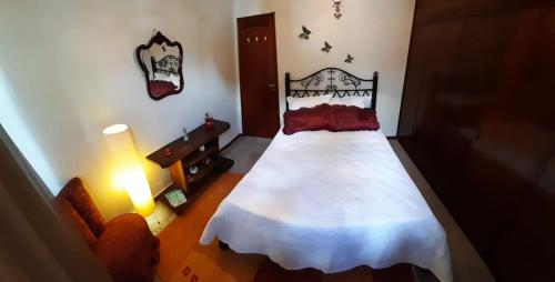 um quarto com uma cama, um candeeiro e um sofá em Fonte da Serra em Teresópolis