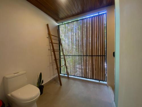 a bathroom with a toilet and a large window at Villa Gaspar Terrazas in Playa hermosa