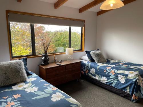 a bedroom with two beds and a window at Amberlea B&B in Hokitika