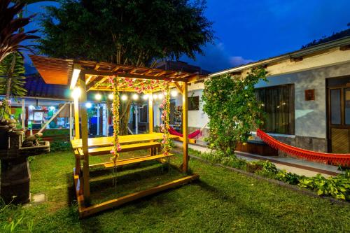 a gazebo in the yard of a house at night at Santa Cruz Backpackers Hostal in Baños