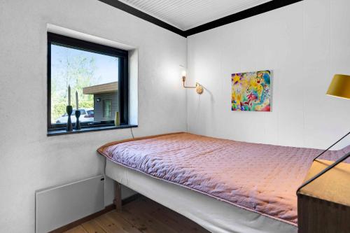 Ce lit se trouve dans un dortoir doté d'une fenêtre. dans l'établissement Lovely Holiday Home Close To Town And Beach, à Græsted
