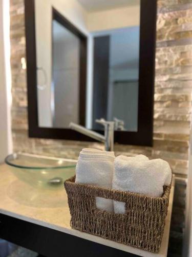 a bathroom with a basket of towels and a sink at Hermoso Departamento en Barrio Jardin in Cordoba