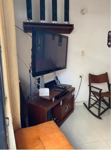 佛洛倫西亞的住宿－APARTAMENTO，客厅配有电视和书桌上的电脑