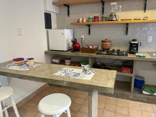 a kitchen with two tables and two white stools at Departamento centro de Boca del Río in Boca del Río