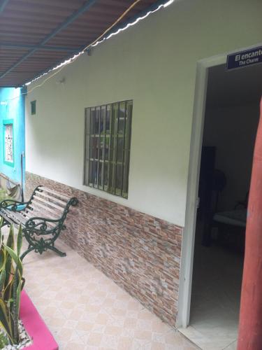a door to a building with a bench and a window at Eco-Cafe El Mirador in Guachaca