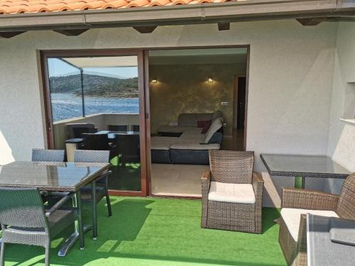 a patio with a table and chairs and a bedroom at Apartments by the sea Kaprije - 20012 in Kaprije