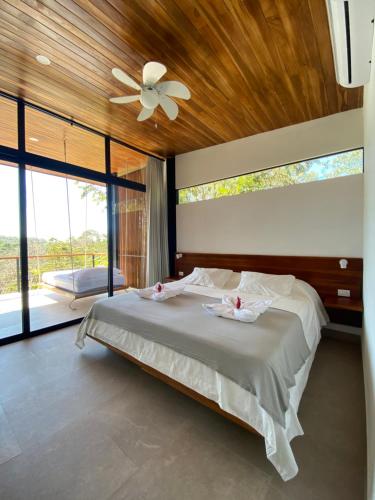 a bedroom with a large bed with a ceiling fan at Villa Gaspar Terrazas in Playa hermosa