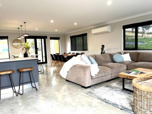 a large living room with a couch and a kitchen at 44onRoaring - in the Huon Valley in Surveyors Bay