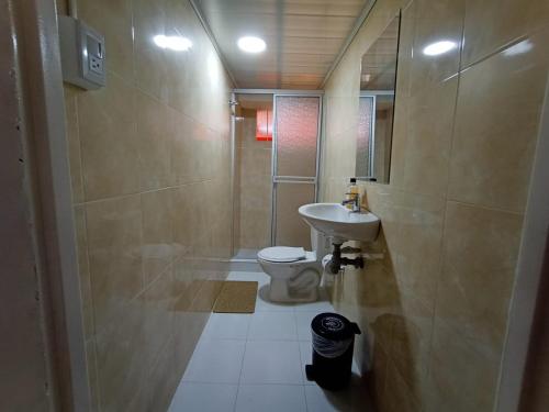 a bathroom with a sink and a toilet at HOTEL BOGOTA AIRPORT DORADO in Bogotá