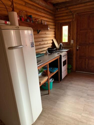 a kitchen with a refrigerator and a stove at Cabañas Piquillin Potrerillos Mendoza in Potrerillos