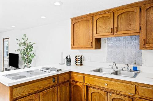 a kitchen with wooden cabinets and a sink at ~New~ Bright and Spacious Back House in Bakersfield