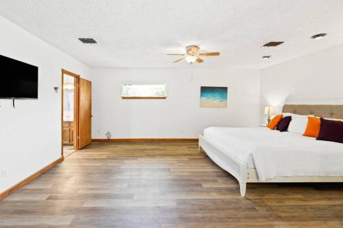 a white bedroom with a bed and a ceiling fan at ~New~ Bright and Spacious Back House in Bakersfield