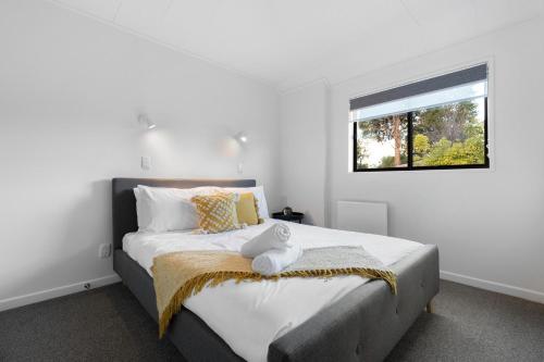 a bedroom with a large bed with a window at Location, Location in Queenstown
