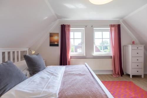 a bedroom with a white bed and two windows at Pura Vida 2 in Tating