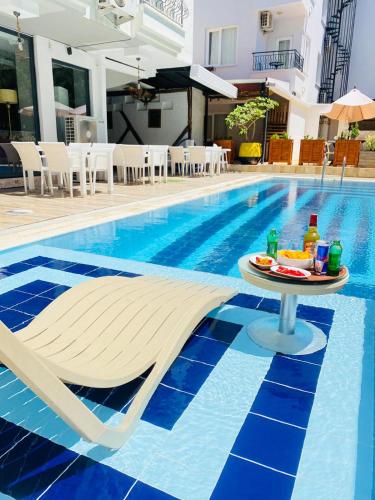 a pool with a table and chairs next to a swimming pool at NFK The House Hotel in Antalya