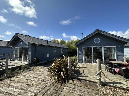 a house with a wooden deck with a fence at Sandy Collection - 2 next door beach houses - Part of the The Bay Filey Holiday Village with pool, gym and direct beach access, pub, restaurant, tennis and meadows walks in Filey