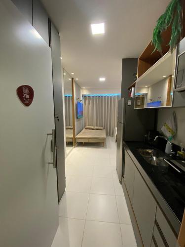 a kitchen with a sink and a room with a couch at Mana Beach Experience Muro Alto C219 in Porto De Galinhas