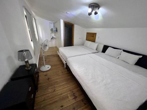 a bedroom with two beds and a fan at Beautiful Home and Pool near beach , BBQ Juan Dolio metro country Club in Juan Dolio